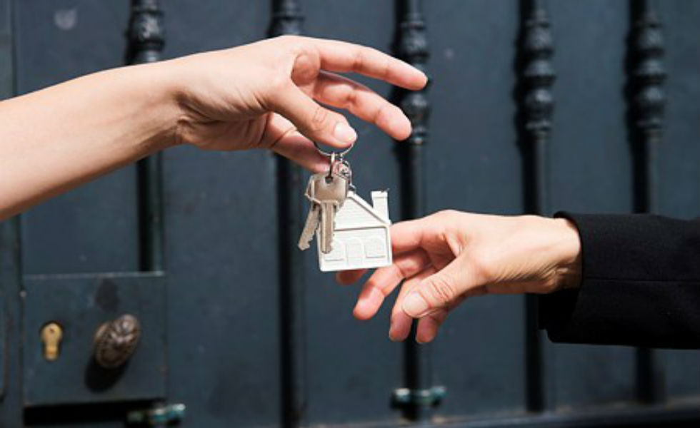 Remise des clefs devant une habitation